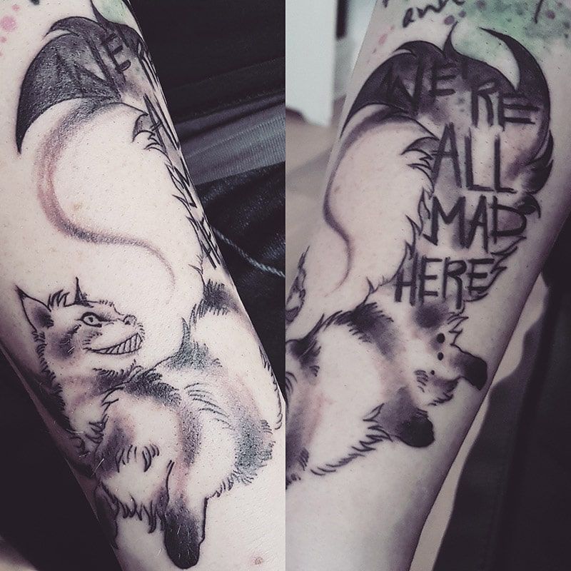 Grinsekatze Tattoo mit Spruch in Schwarz-Weiß